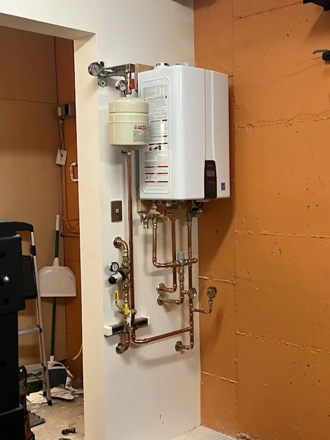 Plumbing technician inspecting water heater connections in Alexandria